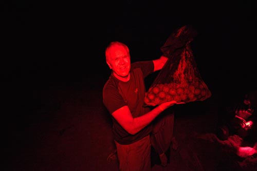 Steve holds a bag of leatherback eggs that must be moved to a nest site away from dangerous ocean tides.
